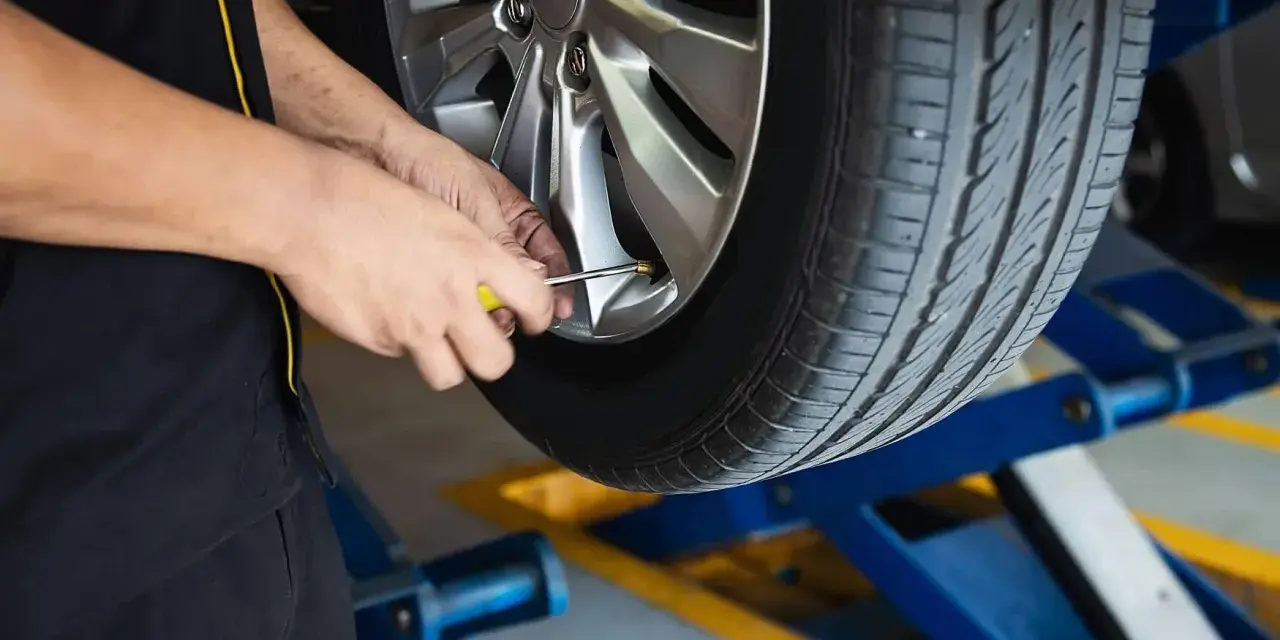 Mechanik sprawdza ciśnienie w oponie. To część usług wulkanizacji, czyli serwisu opon.
