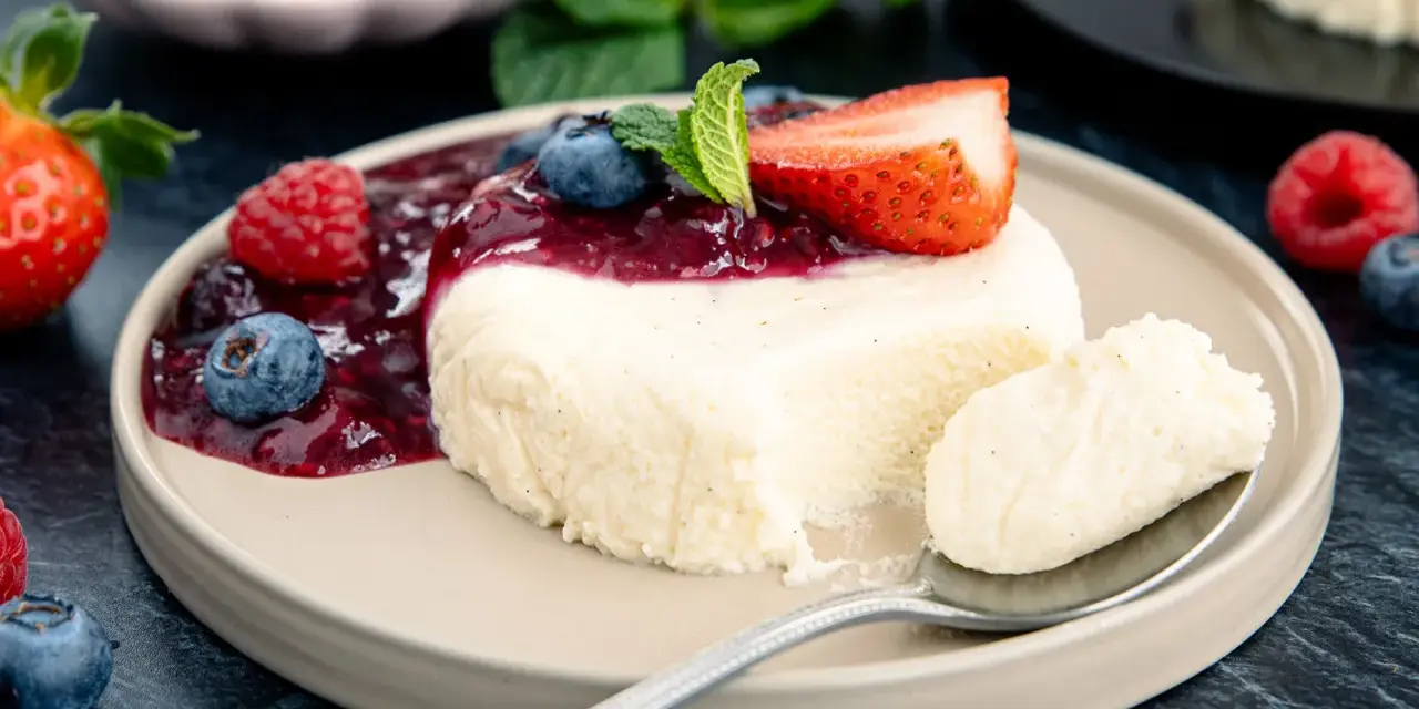 Cremige bayrische Creme mit Beerensoße, Erdbeere und Minze. Ein Löffel voller Genuss.