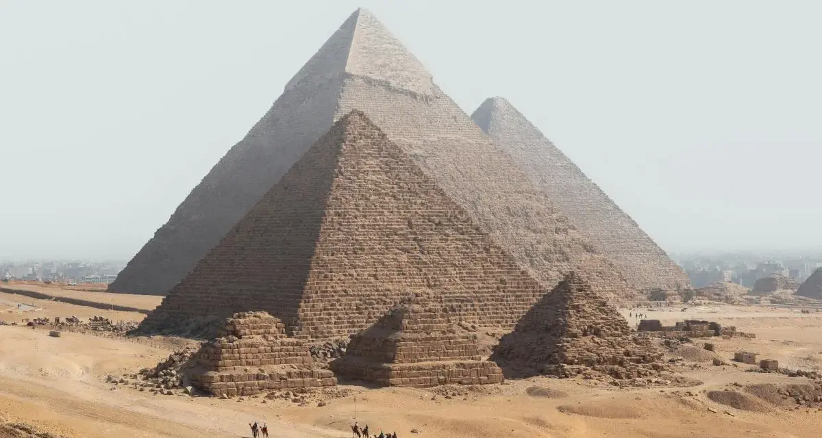 Piramide w Gizie z karawaną wielbłądów na pustyni.