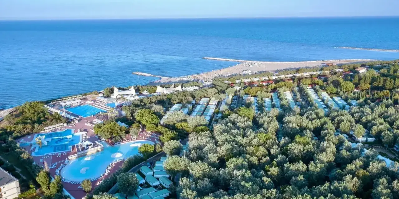 Widok z lotu ptaka na **camping Isamar** z basenami, domkami kempingowymi i plażą nad morzem.
