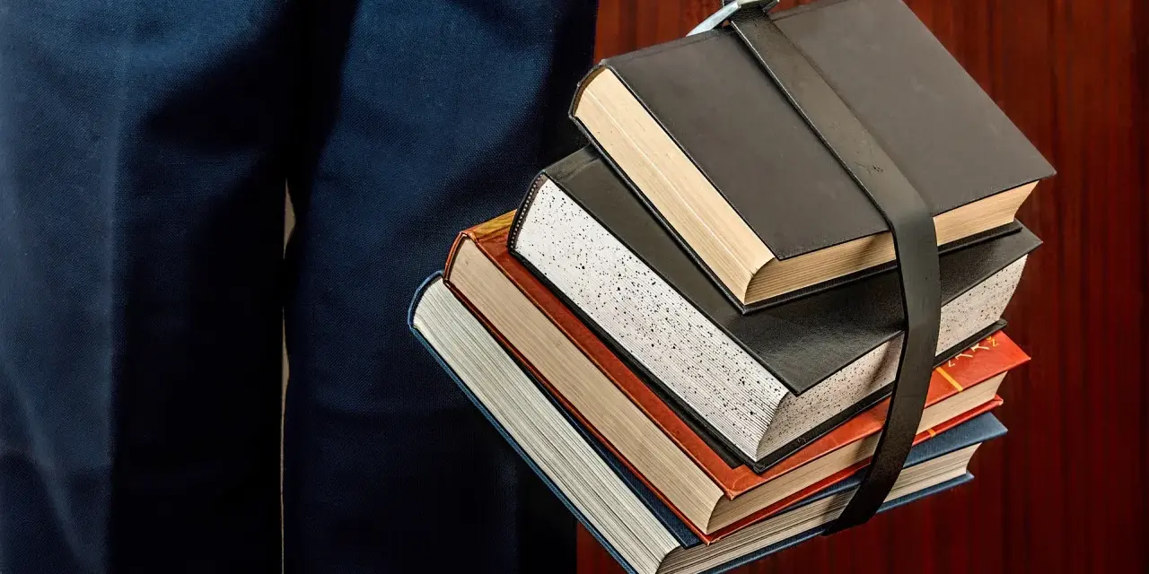 Un fascio di libri legati da una cinghia, un simbolo del percorso per capire come funzionano i CFU e il carico di studio.