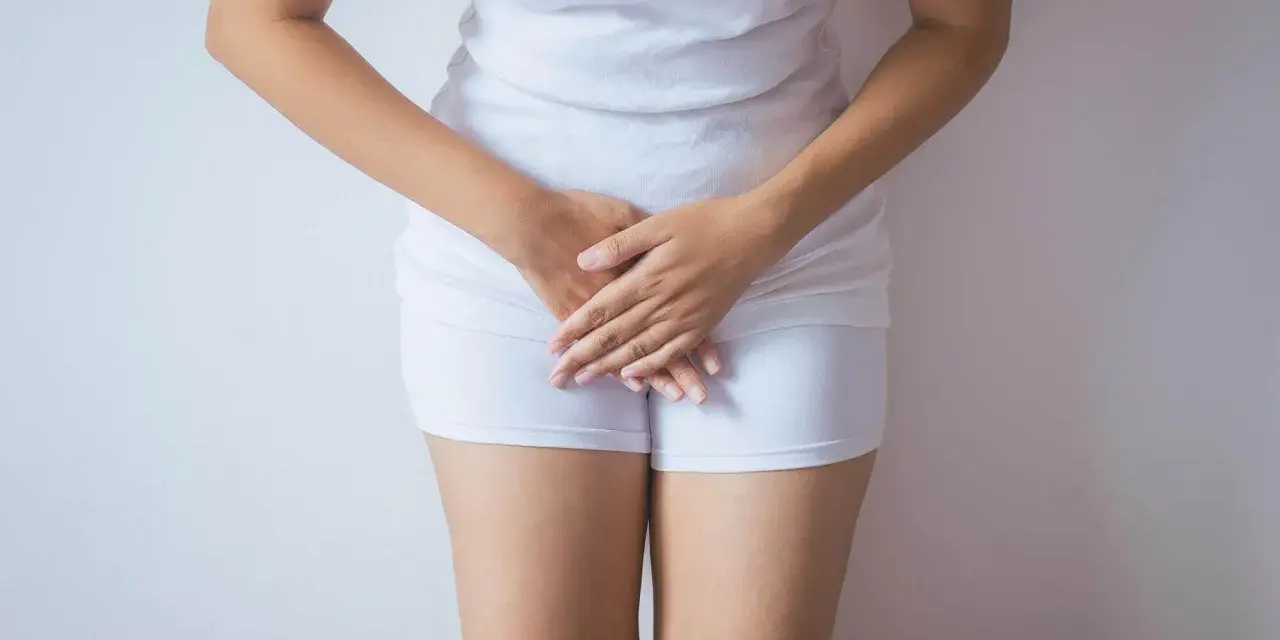 Kobieta w białej bieliźnie, dłonie zasłaniające krocze. Może symbolizować żółte upławy w okresie menopauzy.