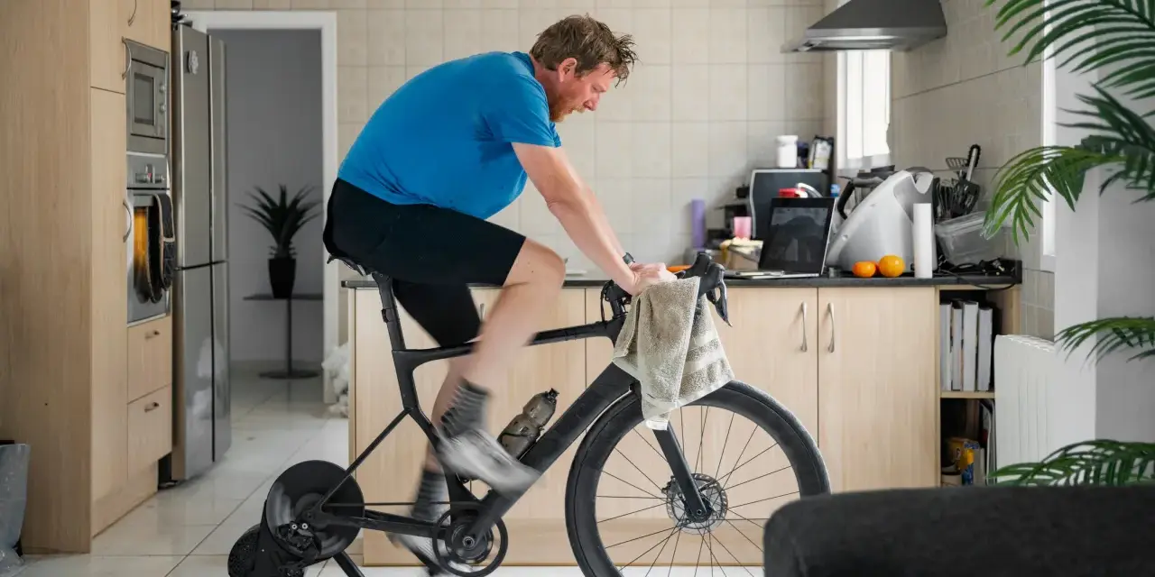 Man doing indoor cycling for beginners in his kitchen.