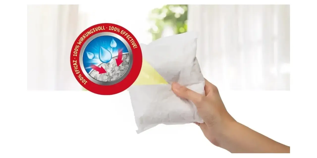 Hand hält Granulat-Beutel für Luftentfeuchter. Das Granulat bindet Feuchtigkeit, die dann als Wasser entsorgt wird. 100% wirkungsvoll.