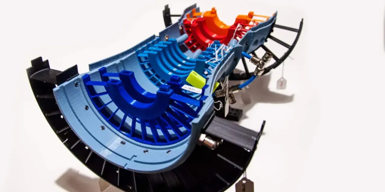 A colorful 3D printed model of a jet engine turbine, showcasing advancements in 3D printing aerospace technology.