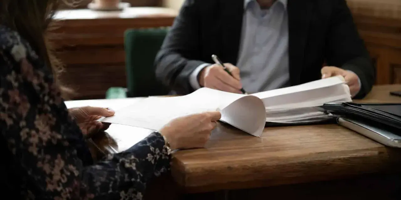 Para, która analizuje dokumenty, aby uzyskać klauzulę wykonalności alimentów.