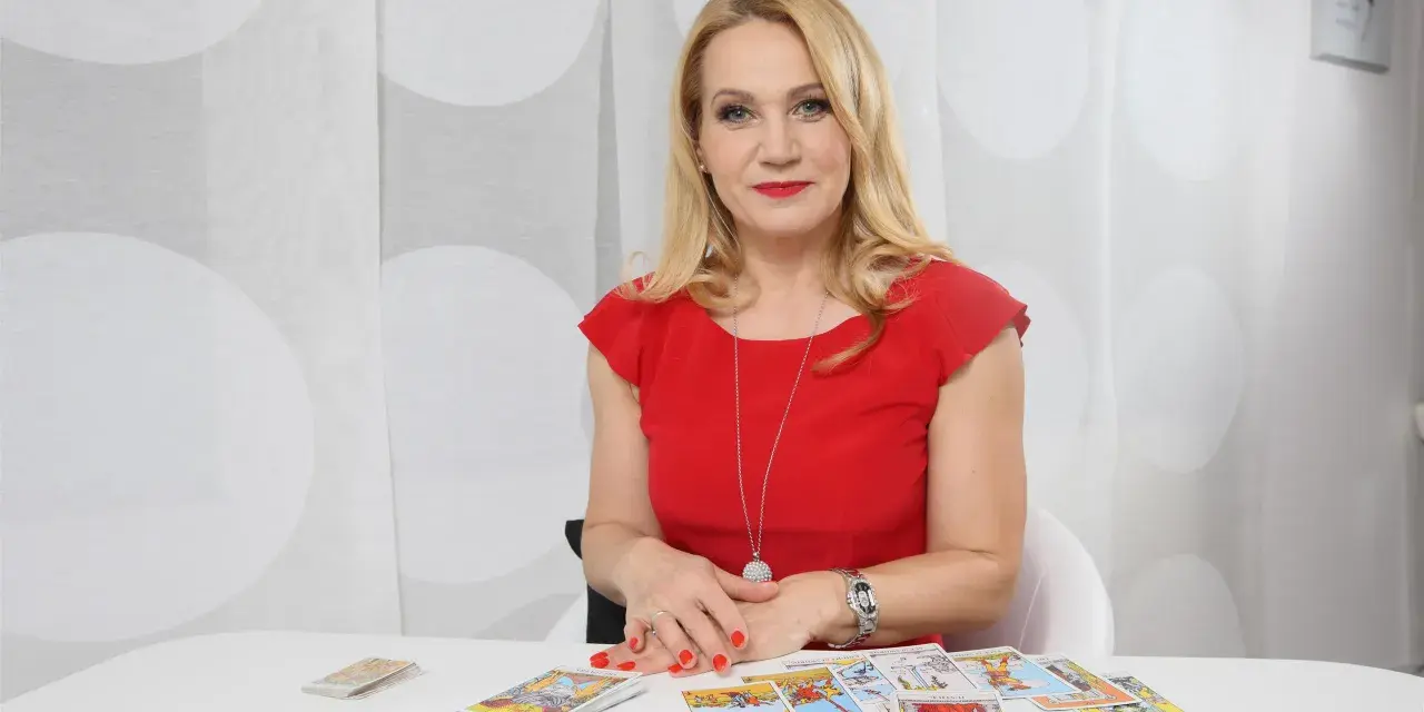 Wróżka Anna w czerwonej sukience rozkłada karty tarota, by odkryć przyszłość.