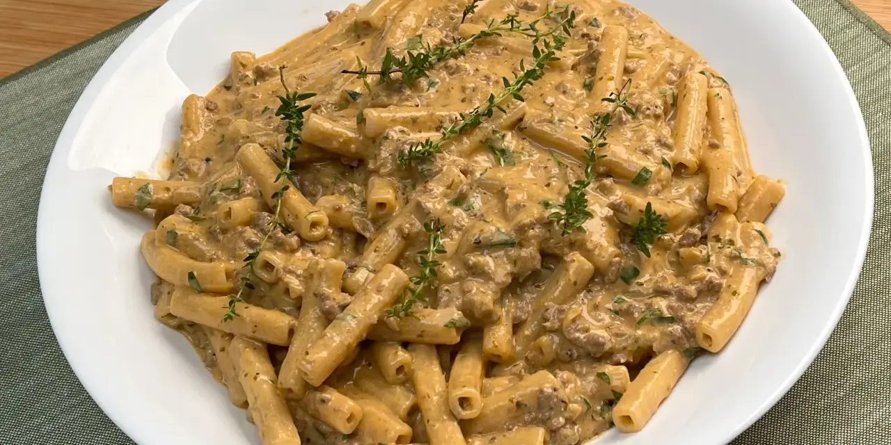 Piatto di pasta alla montecarlo con ragù cremoso e timo fresco.