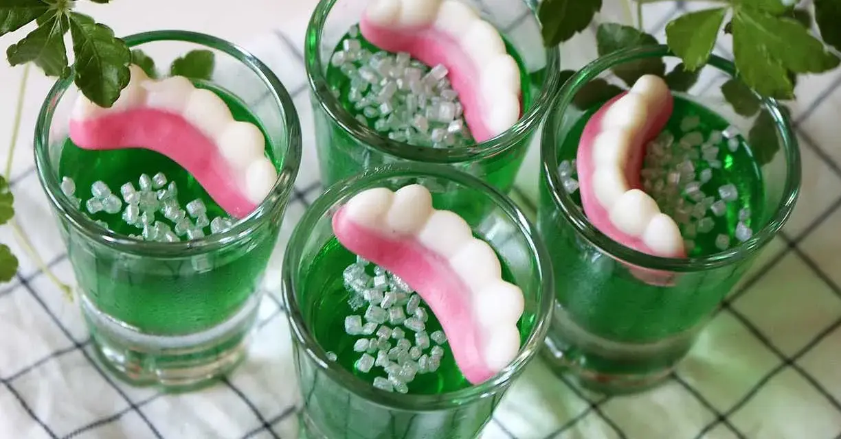 Gröna jello shots med godiständer och strössel. Perfekt för en festlig stämning!