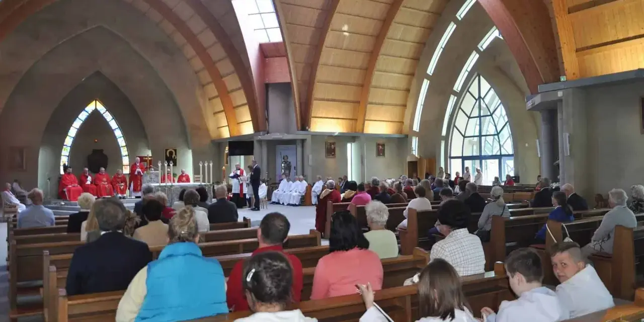 Nabożeństwo w kościele św. Jakuba w Łebie. Wierni siedzą w ławkach, a przy ołtarzu odprawiana jest msza.