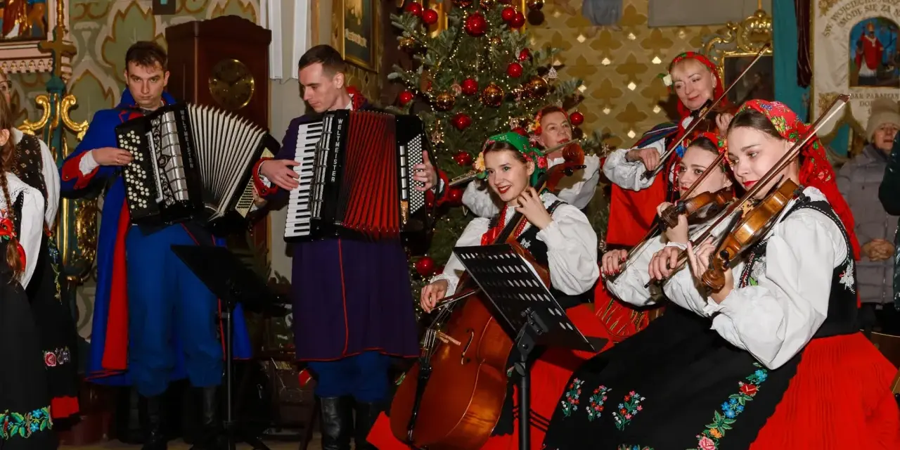 Zespół w strojach ludowych grający wszystkie kolędy polskie przy choince.