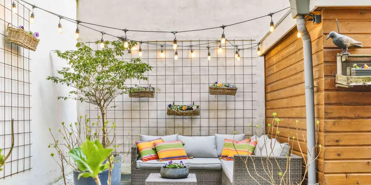 Piccole verande arredate con divano, tavolino e piante. Luci decorative creano un'atmosfera accogliente.