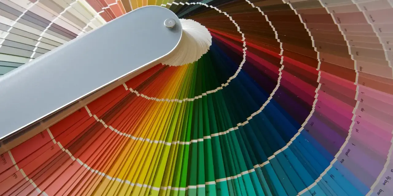 Abanico de muestras de pintura con una amplia paleta colores pastel y vibrantes, ideal para inspirar cualquier proyecto.