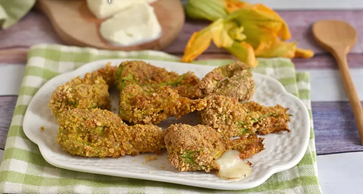 Fiori di zucca ripieni al forno, dorati e croccanti, con un cuore filante di mozzarella.