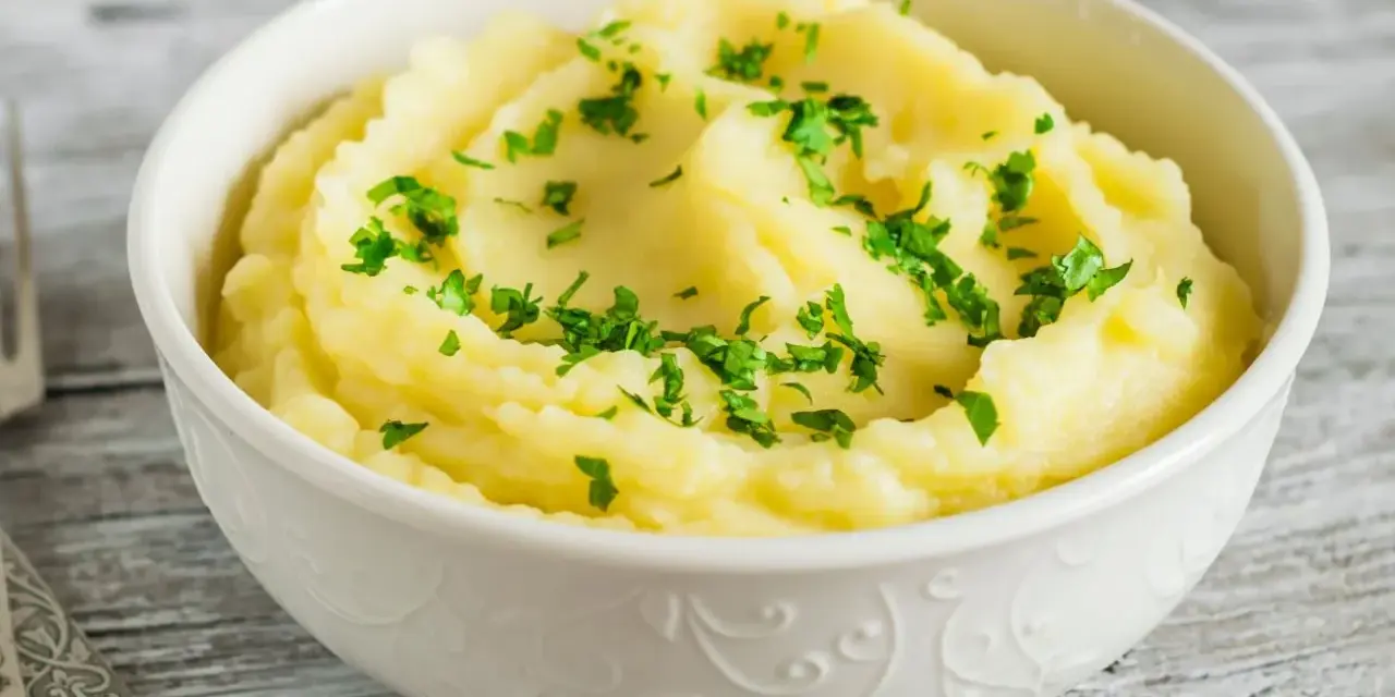 Puszyste, kremowe puree ziemniaczane, posypane świeżą natką pietruszki. Idealny dodatek do obiadu, który pokazuje, jak zrobić puree.