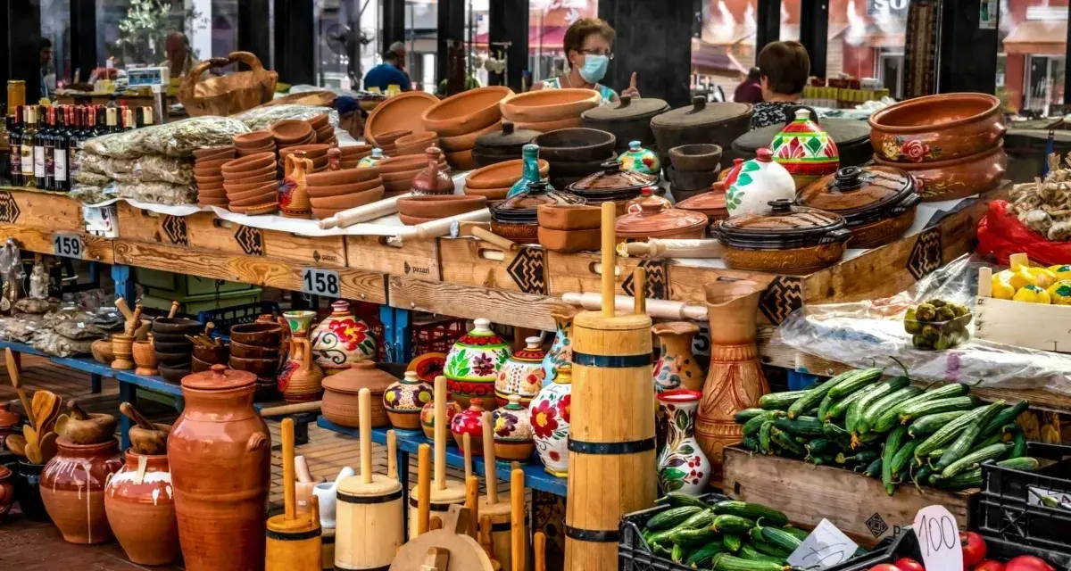 Stoisko z ceramiką, butelkami wina i świeżymi warzywami. Idealne miejsce, by zastanowić się, co przywieźć z Albanii – gliniane naczynia, lokalne produkty czy rękodzieło.