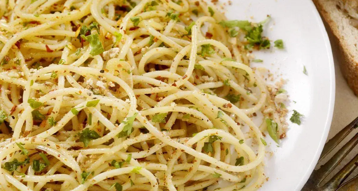Un piatto di spaghetti conditi con aglio, olio, peperoncino e prezzemolo, un classico della pasta alla carrettiera.