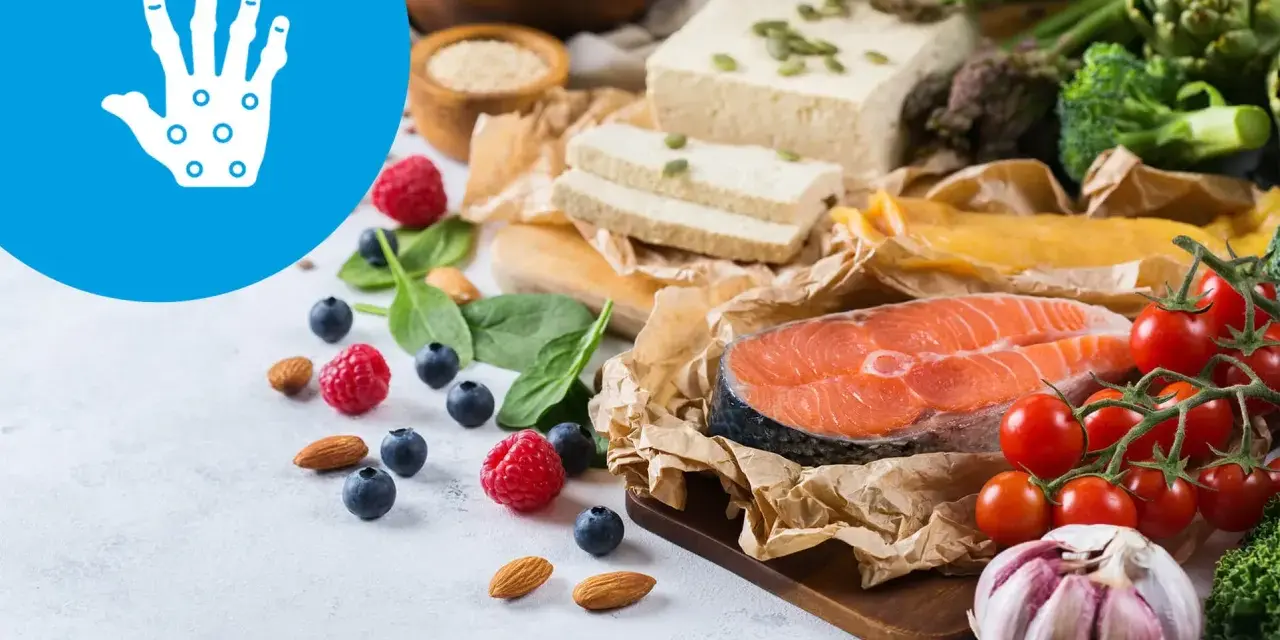 Zdrowa dieta przy łuszczycy: łosoś, warzywa, owoce, orzechy i tofu. Ikona dłoni symbolizuje ulgę.