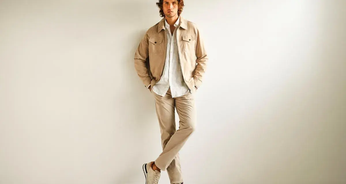 Hombre con ropa business casual en tonos beige: chaqueta, camisa y pantalones.