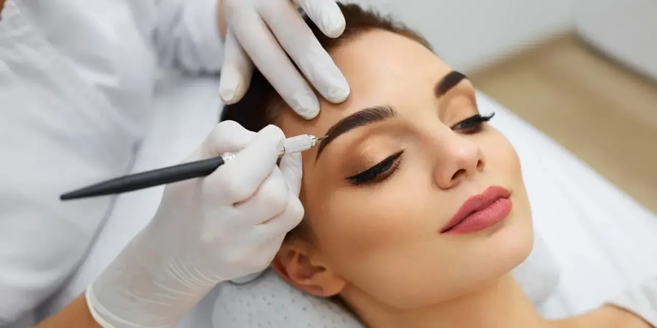 Une esthéticienne crée des sourcils brossés vers le haut sur une cliente, perfectionnant son regard avec précision.