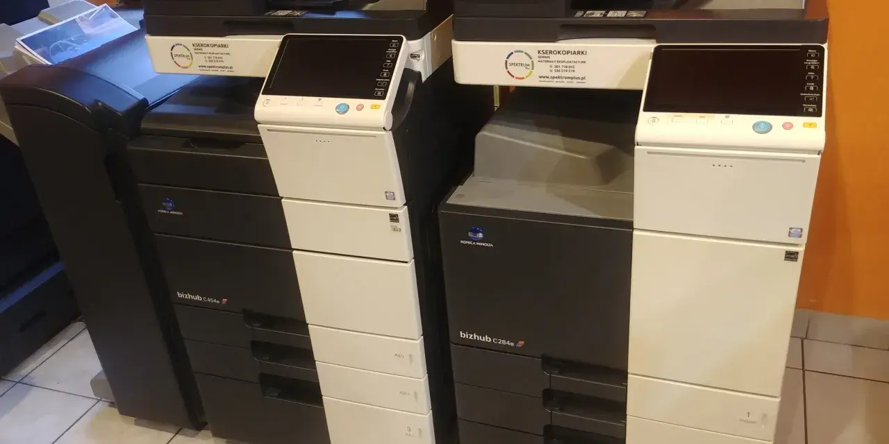 Dwie kserokopiarki Konica Minolta bizhub C454e i C284e stoją obok siebie, gotowe do pracy.