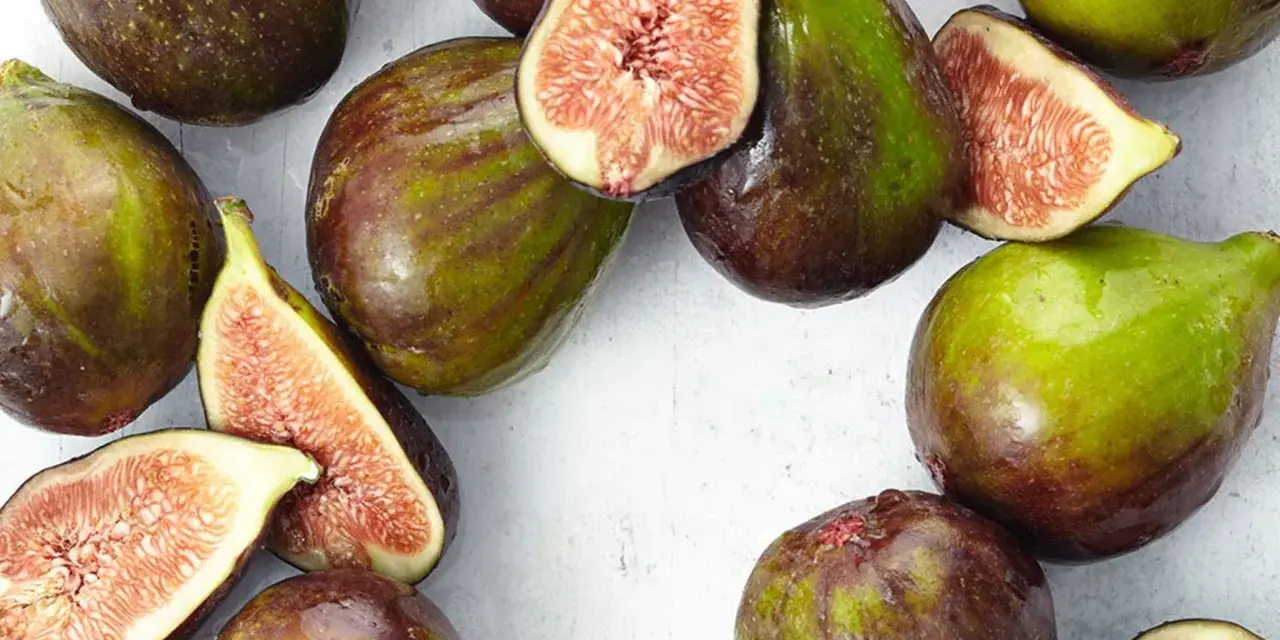 Frische Feigen, teils angeschnitten, zeigen ihr saftiges Inneres. Man fragt sich, wie schmecken feigen wohl? Süß und honigartig.