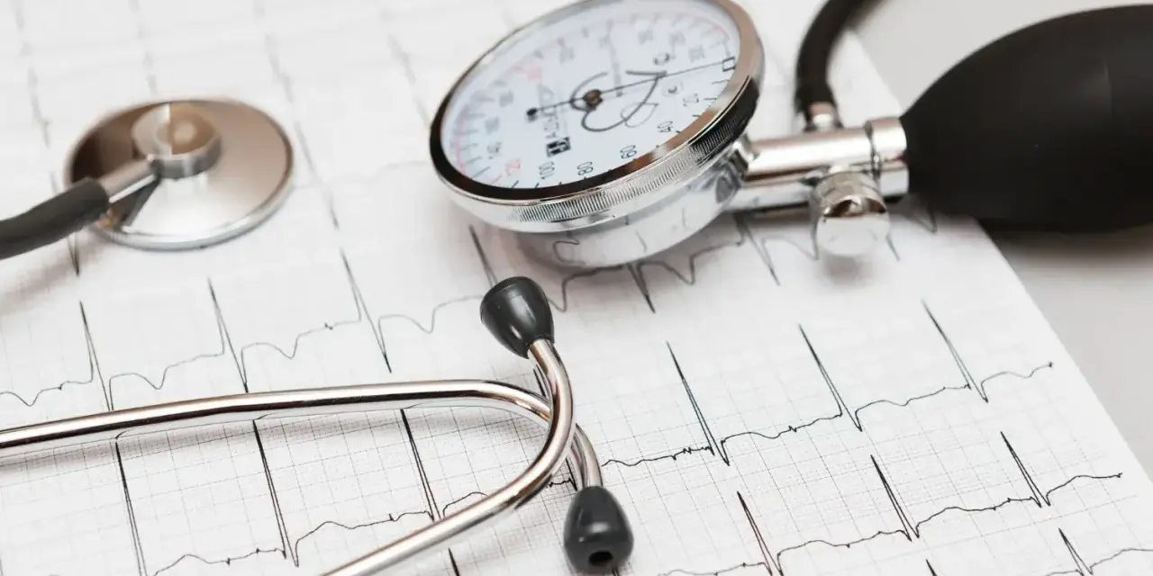 Stetoskop i ciśnieniomierz na tle zapisu EKG.