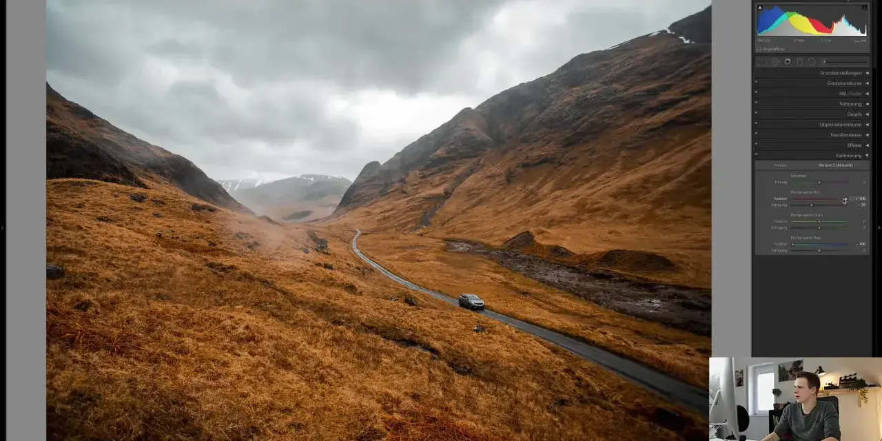 Paysage écossais traité dans Lightroom, avec une voiture sur une route sinueuse. L'ouverture sur la lumière de Lightroom France révèle des teintes chaudes et dramatiques.