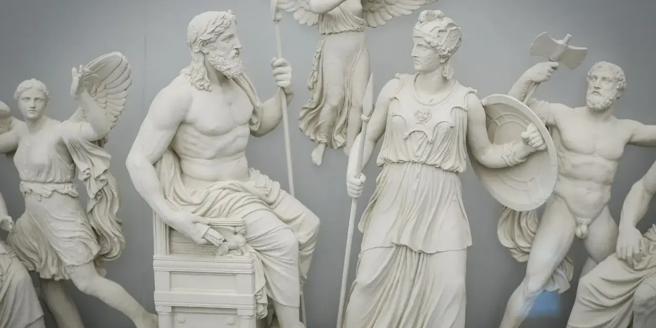A frieze depicting ancient pagan gods and goddesses, with Zeus seated and Athena standing, surrounded by winged figures and warriors.
