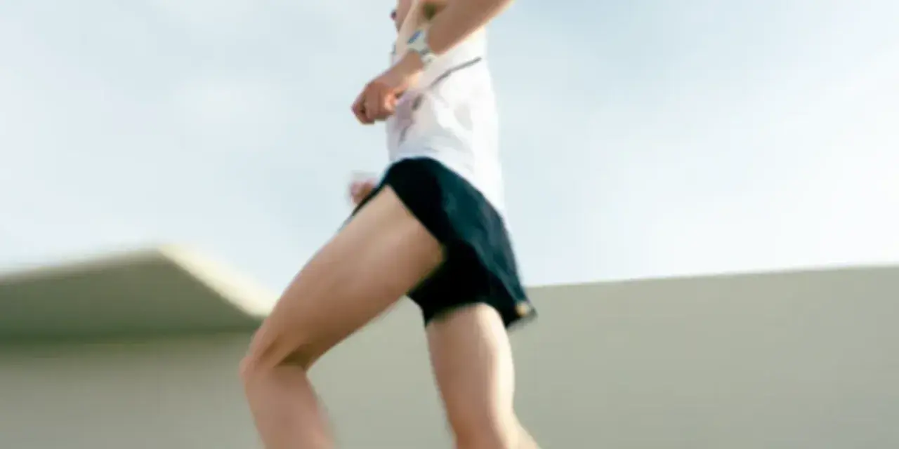 Un atleta corre a tutta velocità, mostrando quanto corre veloce un uomo. Le gambe muscolose si muovono rapidamente, catturando l'essenza della velocità.