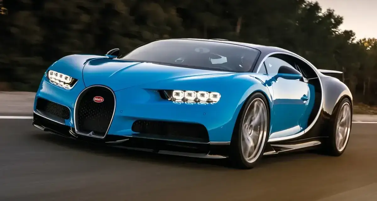 Niebieski Bugatti Chiron pędzi po drodze. Jego cena jest astronomiczna, ale wrażenia z jazdy bezcenne.