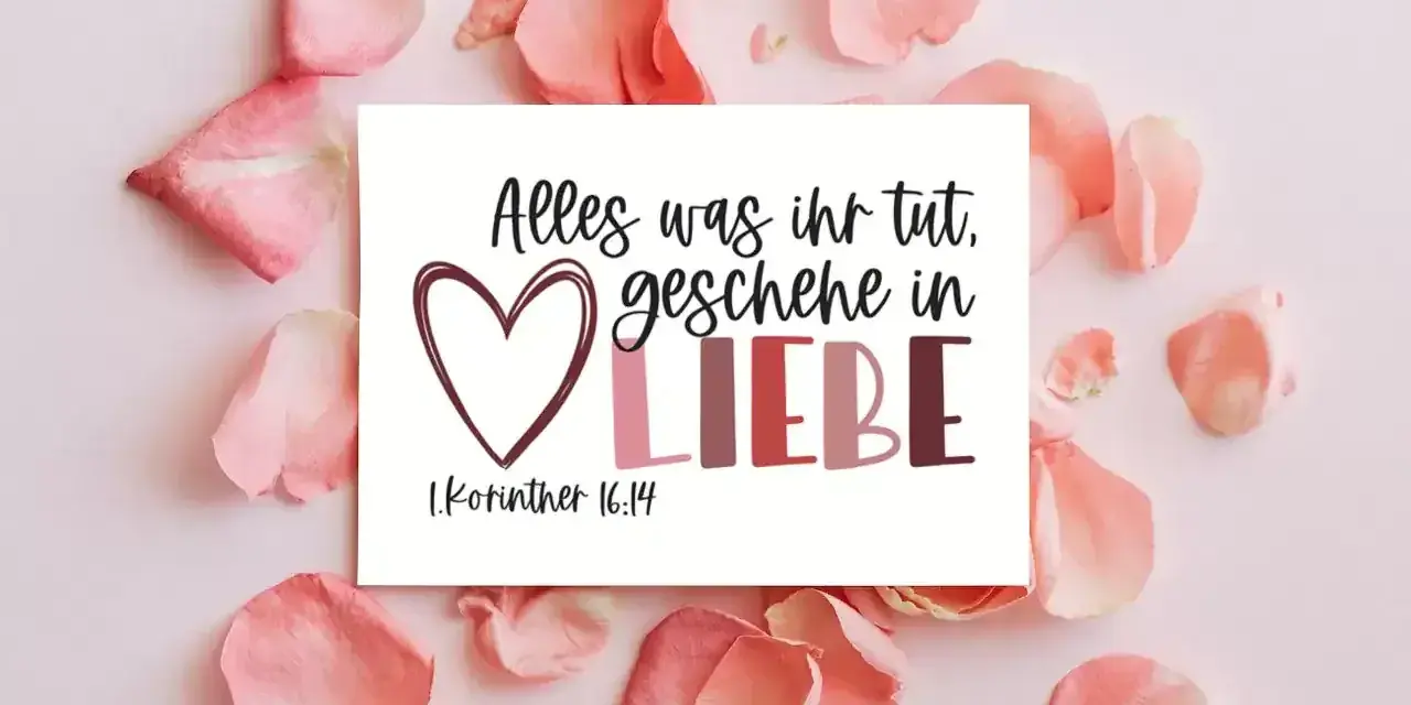Herzförmige Karte mit dem Spruch "Alles was ihr tut, geschehe in LIEBE. 1.Korinther 16:14", umgeben von zarten rosa Blütenblättern.