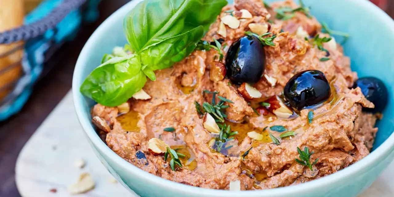 Herzhafte Dip Rezepte: Cremiger Dip mit Oliven, Mandeln und Basilikum, beträufelt mit Olivenöl. Perfekt zum Dippen!