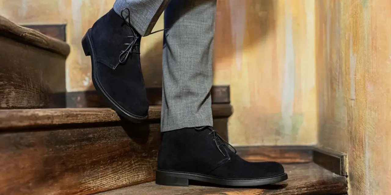 Eleganza casual: polacchine uomo scamosciate nere con pantaloni grigi, un abbinamento perfetto per un look sofisticato.
