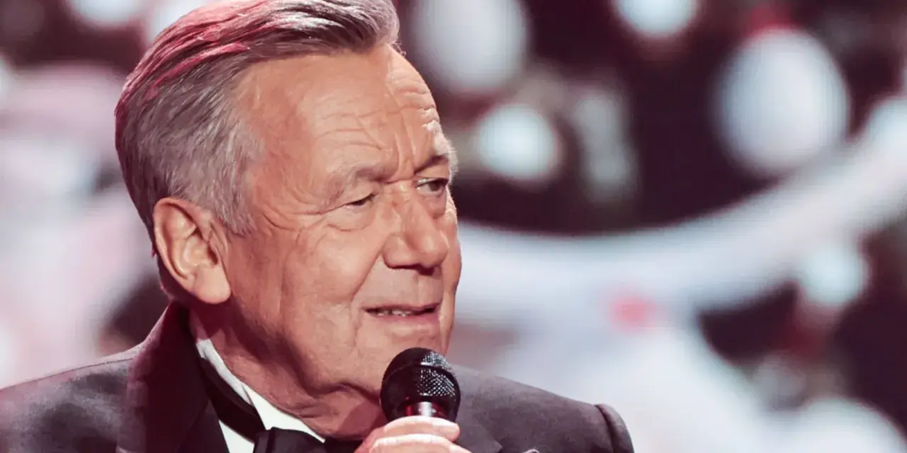 Roland Kaiser singt mit Mikrofon, im Anzug mit Fliege.