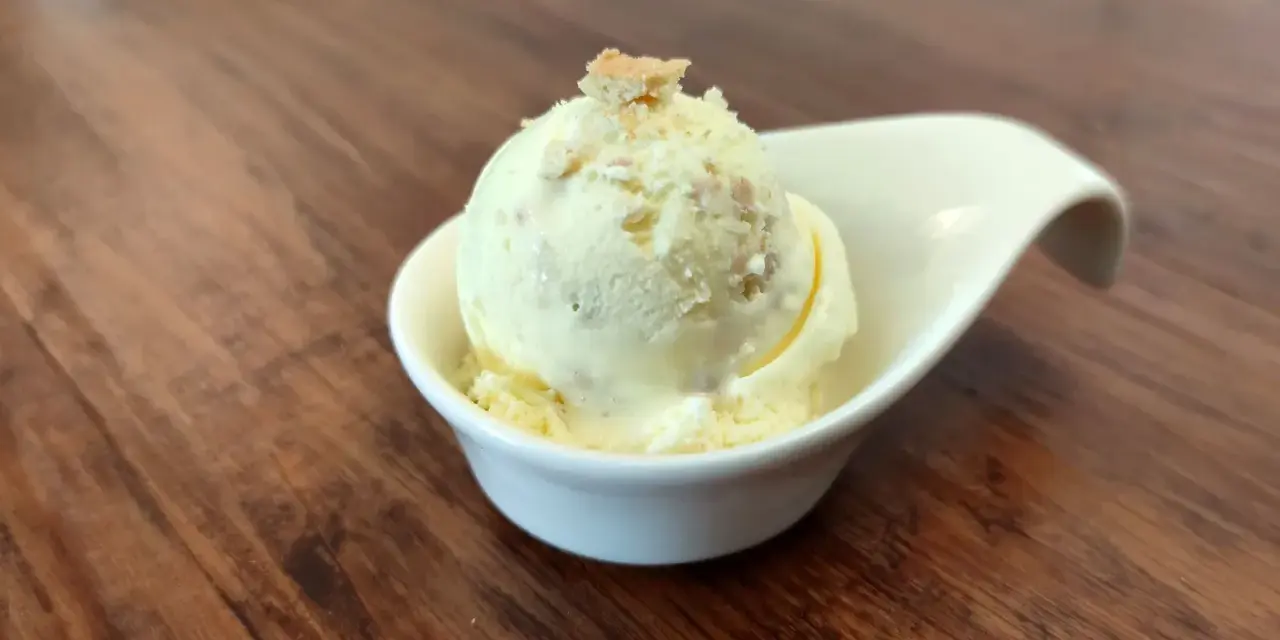 Cremiges Butterkeks Eis in einer weißen Schale, garniert mit Butterkeks-Krümeln. Ein Genuss für warme Tage.