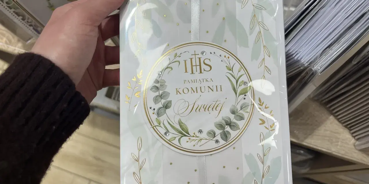 Chrzestny szuka idealnego prezentu. Elegancka pamiątka Komunii Świętej dla dziewczynki, ozdobiona złotymi gałązkami i kryształkami.