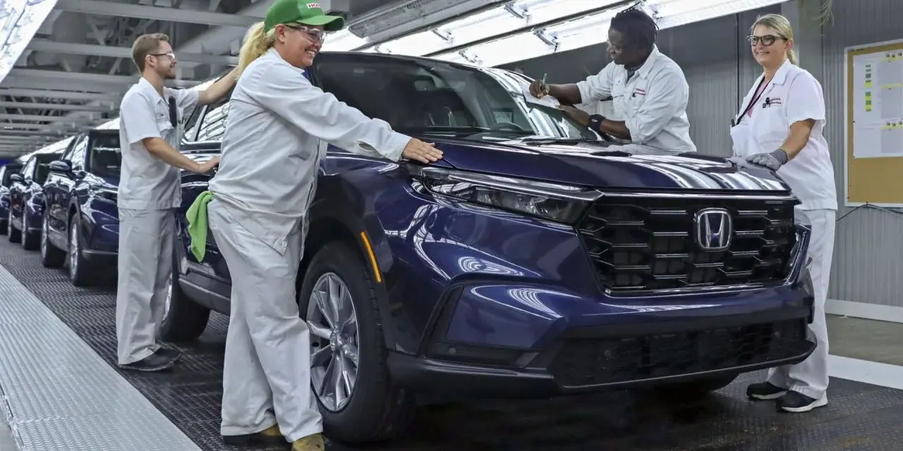 Pracownicy w fabryce Hondy z Japonii kontrolują nowy, ciemnoniebieski SUV.