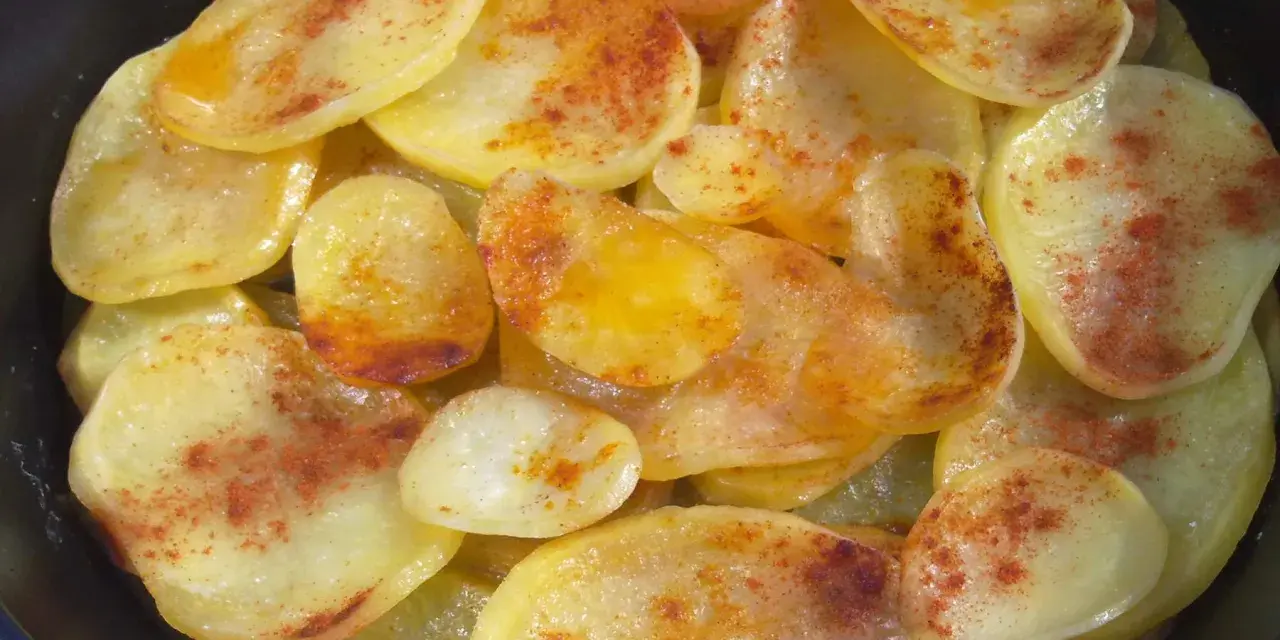 Rodajas de patatas fritas al horno, doradas y espolvoreadas con pimentón.