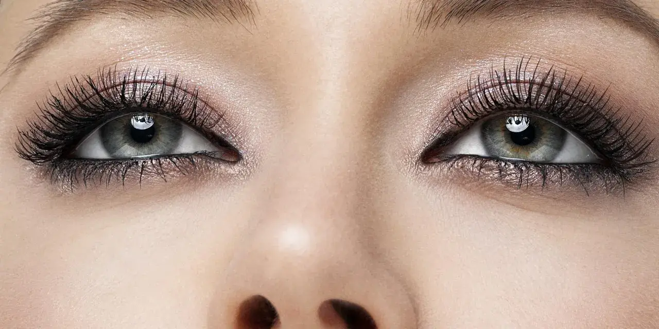 Oczy z makijażem smoky eyes, podkreślone długimi rzęsami i błyszczącym cieniem.