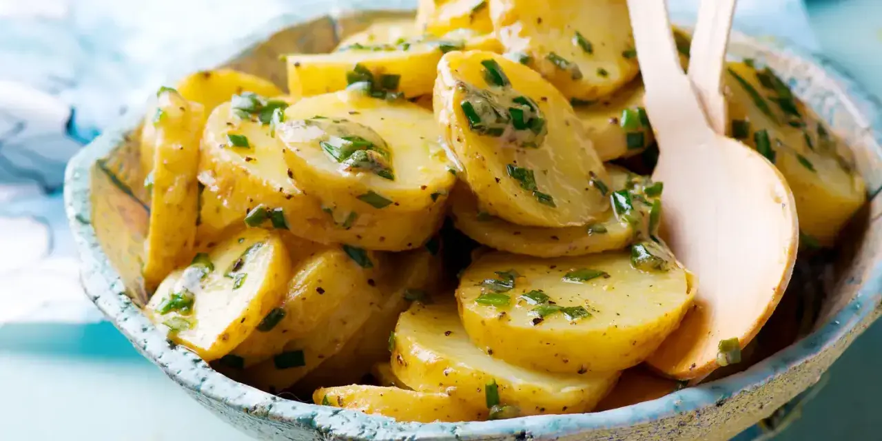 Salade de pommes de terre aux herbes fraîches, nappée d'une vinaigrette savoureuse. Un délice pour accompagner vos repas.