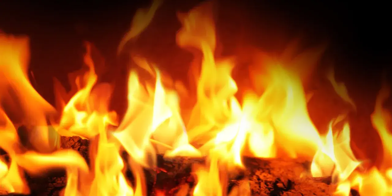 Fiamme vivaci danzano su legna ardente. La stufa a pellet si accende da sola, creando un'atmosfera calda e accogliente.