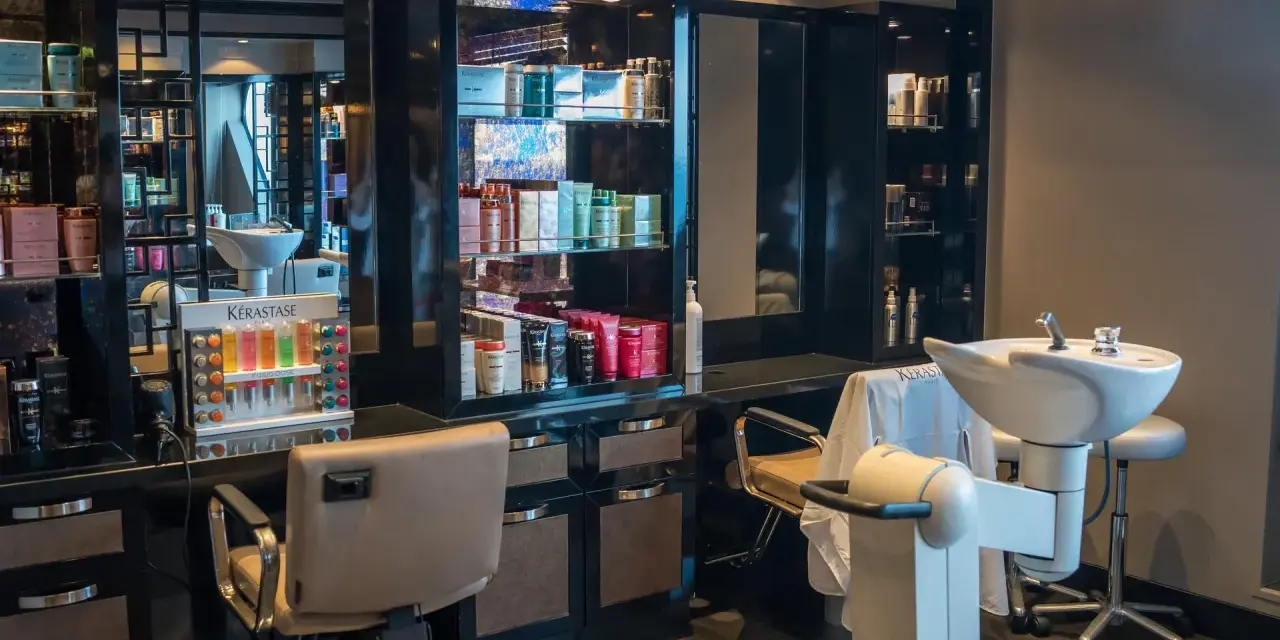 Salon fryzjerski gotowy na klientów. Widać fotele, umywalki i półki z kosmetykami. Dbałość o dezynfekcję w salonie fryzjerskim to podstawa.