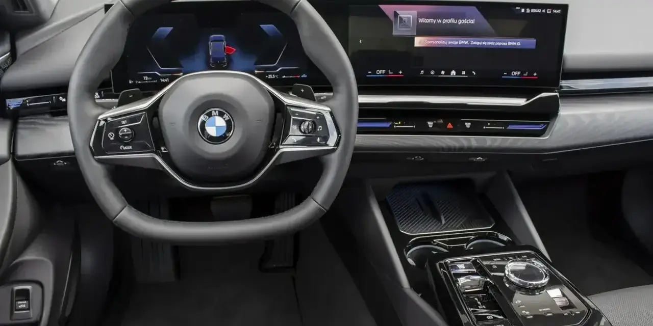 Wnętrze BMW 520d xDrive z nowoczesnym ekranem i kierownicą.