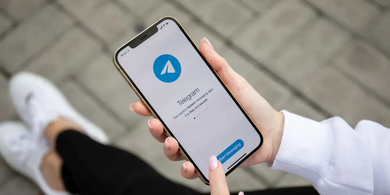 Dłoń trzyma smartfon z otwartą aplikacją Telegram. To szybka i bezpieczna apka do wysyłania wiadomości.