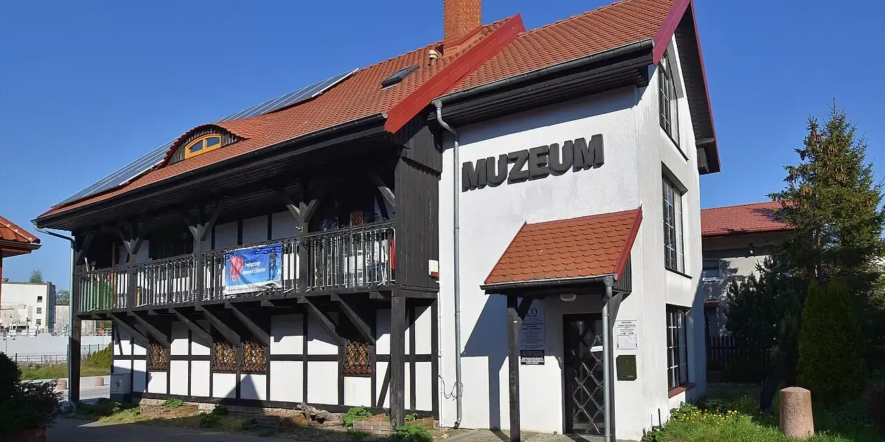 Muzeum Ziemi Usteckiej, z charakterystyczną architekturą szachulcową i nowoczesnymi panelami słonecznymi na dachu, zaprasza do odkrywania historii regionu.