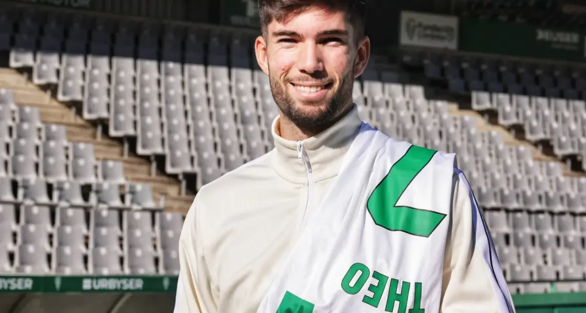 Théo Zidane sonríe con una bufanda del equipo en el estadio.
