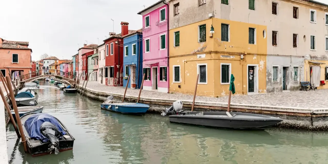 Case colorate e canali, un'immagine che ispira su dove soggiornare a Venezia, magari in un'isola pittoresca.