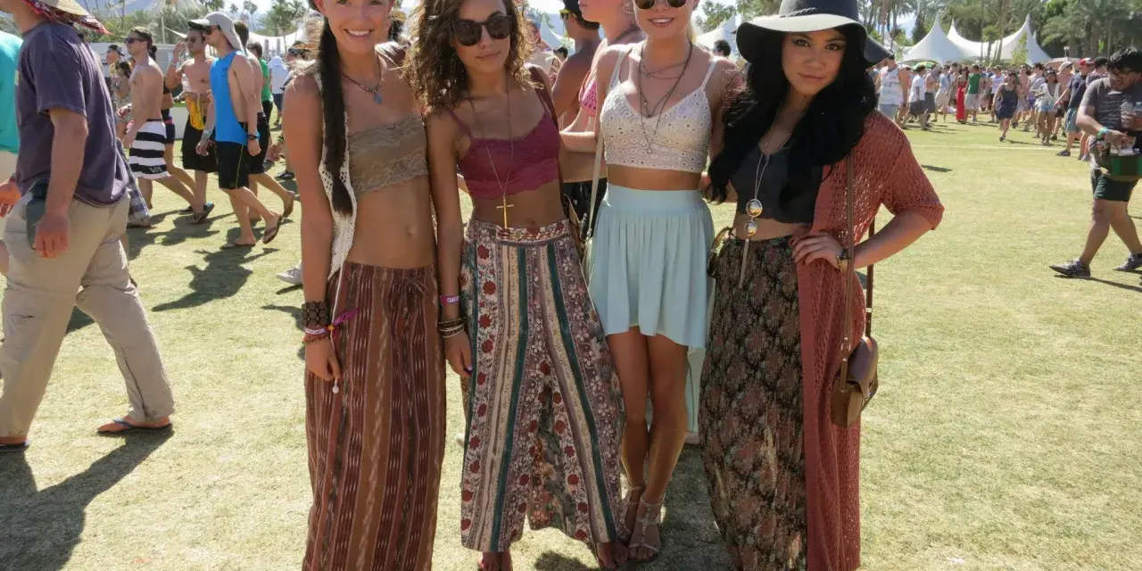 Cztery dziewczyny w letnich strojach pozują na tle festiwalu. W tle widać diabelski młyn. Ile trwa Coachella? Zwykle dwa weekendy.