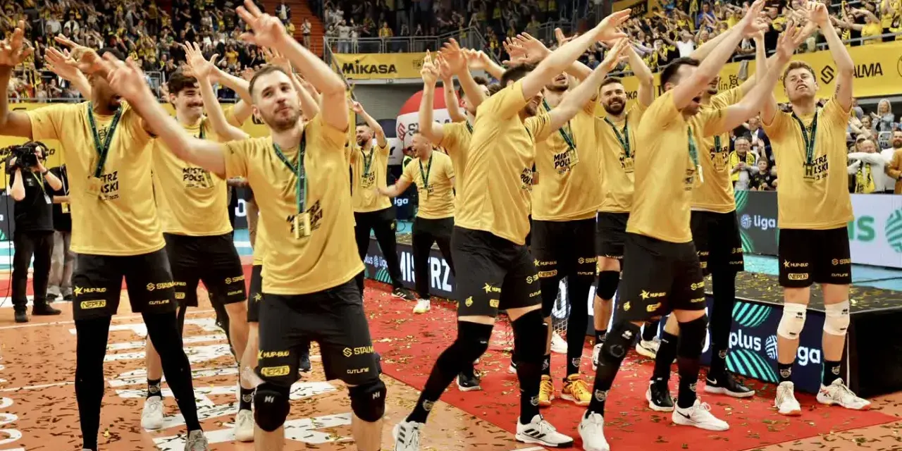 Drużyna MKS Lublin świętuje zwycięstwo na boisku, otoczona konfetti i wiwatującymi kibicami.